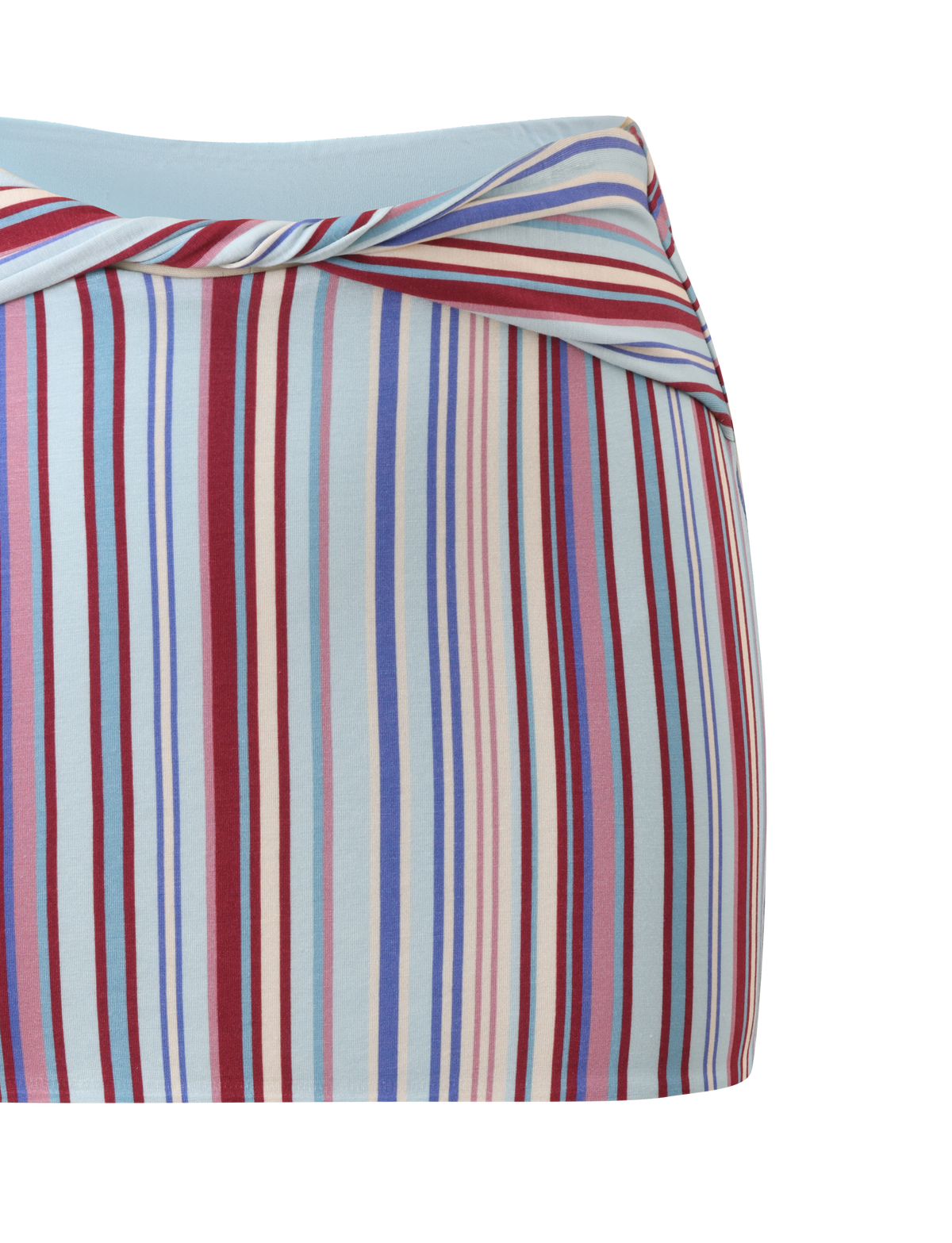 A close-up of the TIGERMIST HAZE TWIST SKIRT - VARIEGATED STRIPE, a fitted mini skirt with a diagonal waistband and vertical red, blue, purple, and white stripes on light blue. Soft, stretchy fabric ensures comfort.