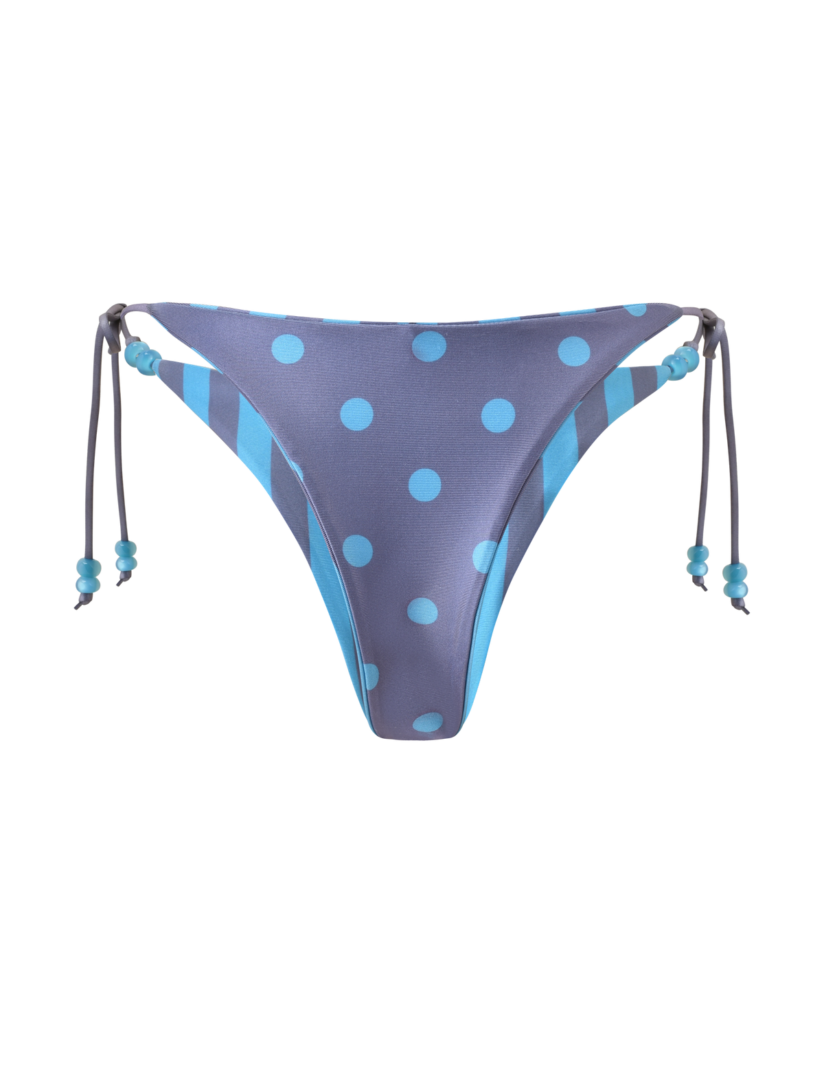 The FINLEA REVERSIBLE BIKINI BOTTOM by TIGERMIST features a blue-grey cheeky cut with polka dots, side ties adorned with three blue beads on each, and a plain white background. Reversible design offers stylish versatility.