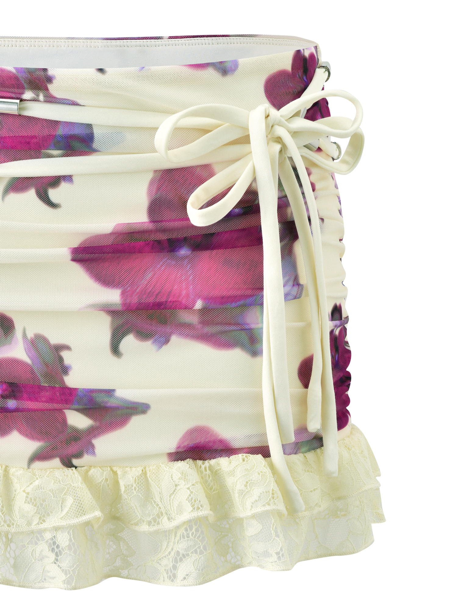 The LILIAH MINI SKIRT - ORCHID HAZE by TIGERMIST features cream fabric, side ruching, a bow tie accent, vibrant orchid print, and a frilled lace hem.