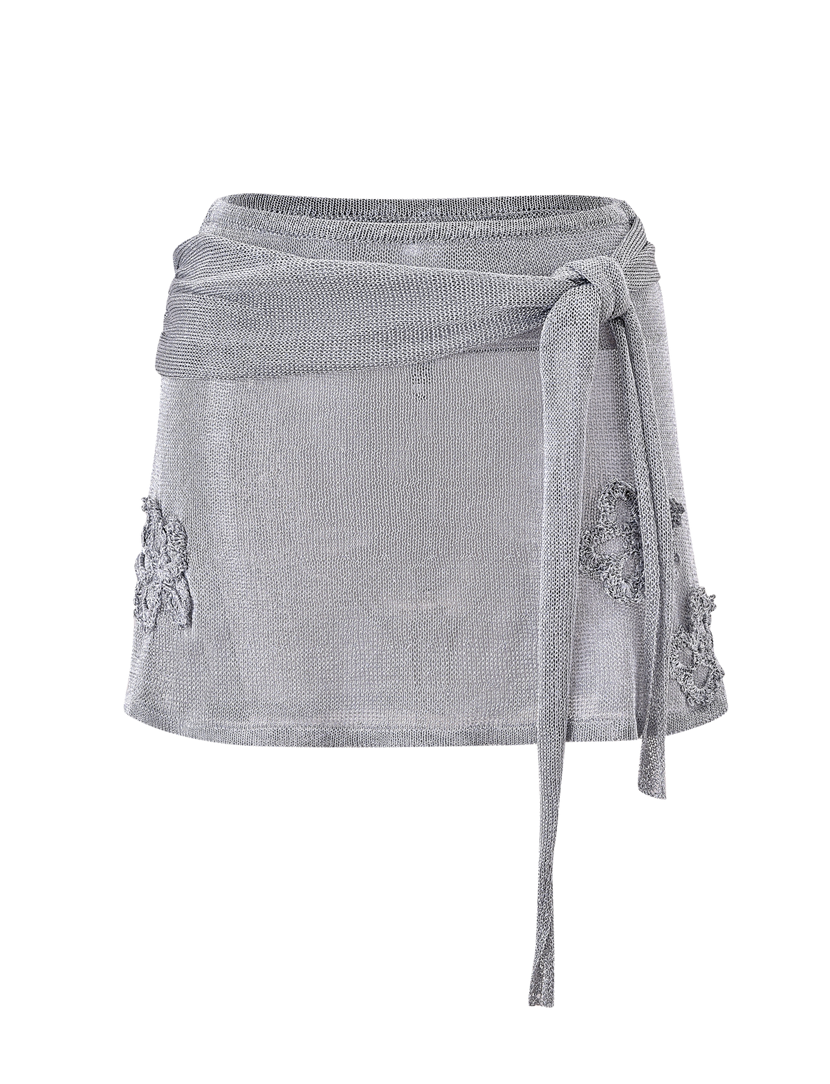 The TIGERMIST ISATANA MINI SKIRT - SILVER is a light gray, semi-sheer mini skirt featuring a wraparound waist tie and floral appliqué details on the sides, shown against a plain white background.