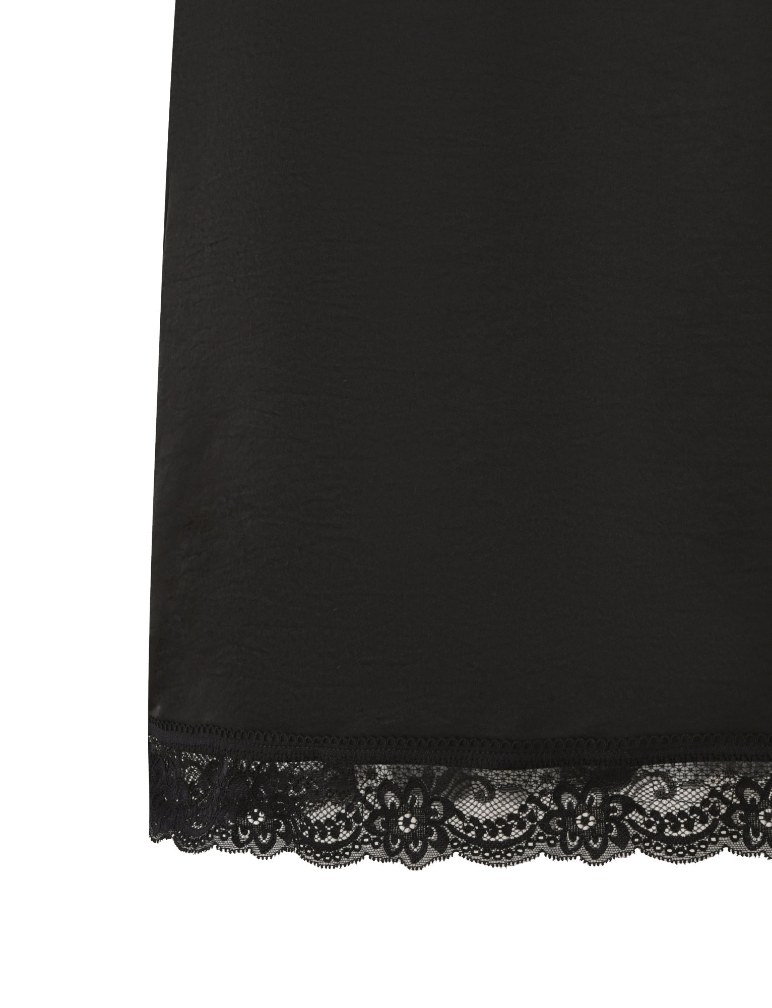 Close-up of the hem of the LEISEL SKIRT - BLACK by TIGERMIST, showcasing a scalloped lace trim with floral patterns. The rest of the fabric is smooth and unadorned.