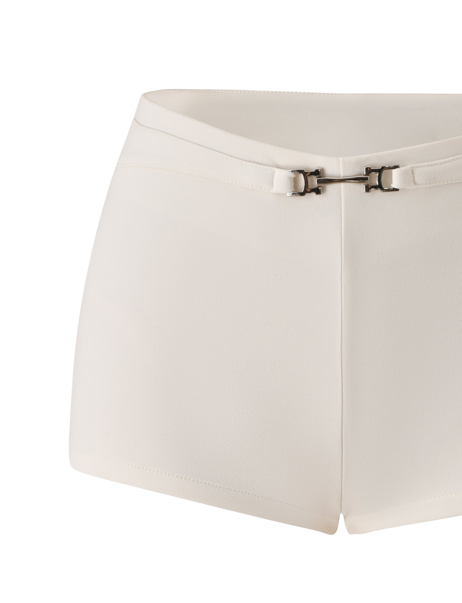The KITTIE BUCKLE SHORT - CREAM by TIGERMIST is a white, high-waisted short crafted from stretch suiting fabric, featuring a fitted silhouette and a thin matching belt with a small silver buckle detail at the front, inspired by the signature Kittie Buckle Pant.
