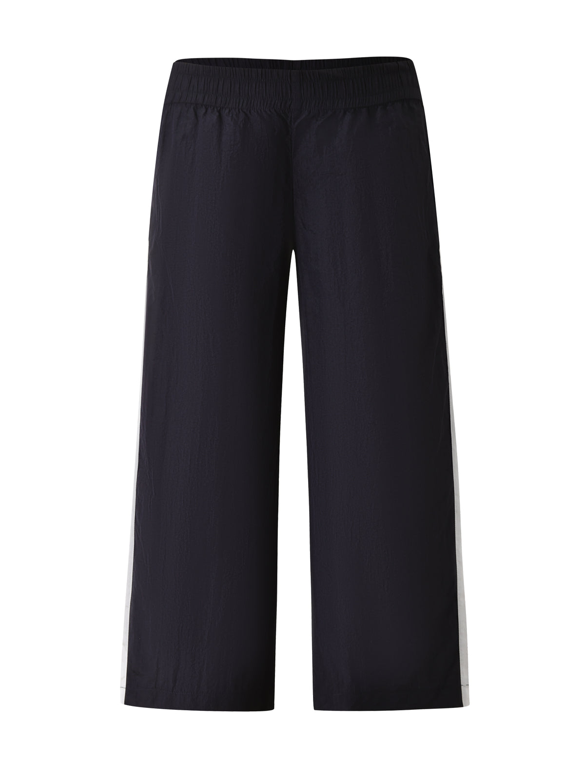 The SOPHIA WINDBREAKER CAPRI by TIGERMIST showcases wide-leg navy pants made from lightweight windbreaker material, designed with an elastic waistband and bold white side stripes, presented against a white background.