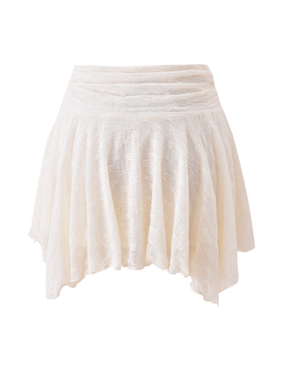 The TIGERMIST MYLAH MINI SKIRT in ivory features textured lace fabric, eyelet details, a flared handkerchief hem, and a ruched waistband, shown against a white background.