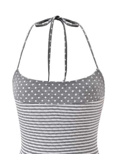 The DASHIELL TOP by TIGERMIST is a heather grey rib knit halter top with adjustable neck ties, featuring white polka dots on the upper section and horizontal white stripes on the lower part.