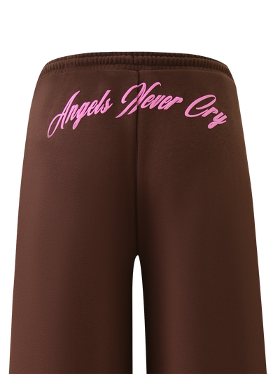 The TIGERMIST MERRYN TRACK PANT - CHOCOLATE features a brown wide-leg design with pink cursive "Angels Never Cry" text on the back, displayed against a white background.