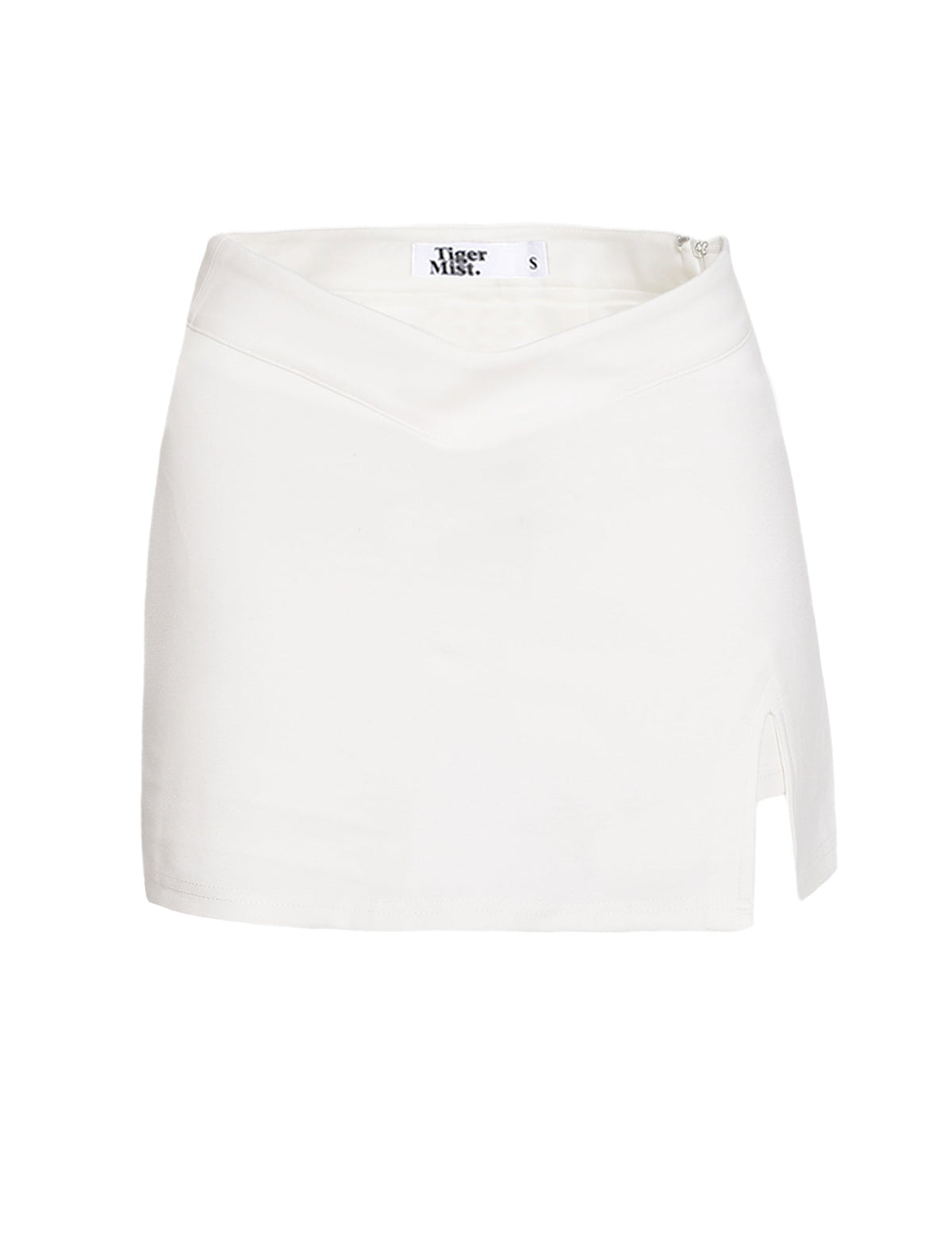 The DAPHNIE SKORT - WHITE by TIGERMIST is a mini-length skort featuring a subtle V-shaped waistband and a small slit on the right side. Made from smooth fabric, it offers a mid-rise fit and includes an internal label with "Tiger Mist" and size "S.