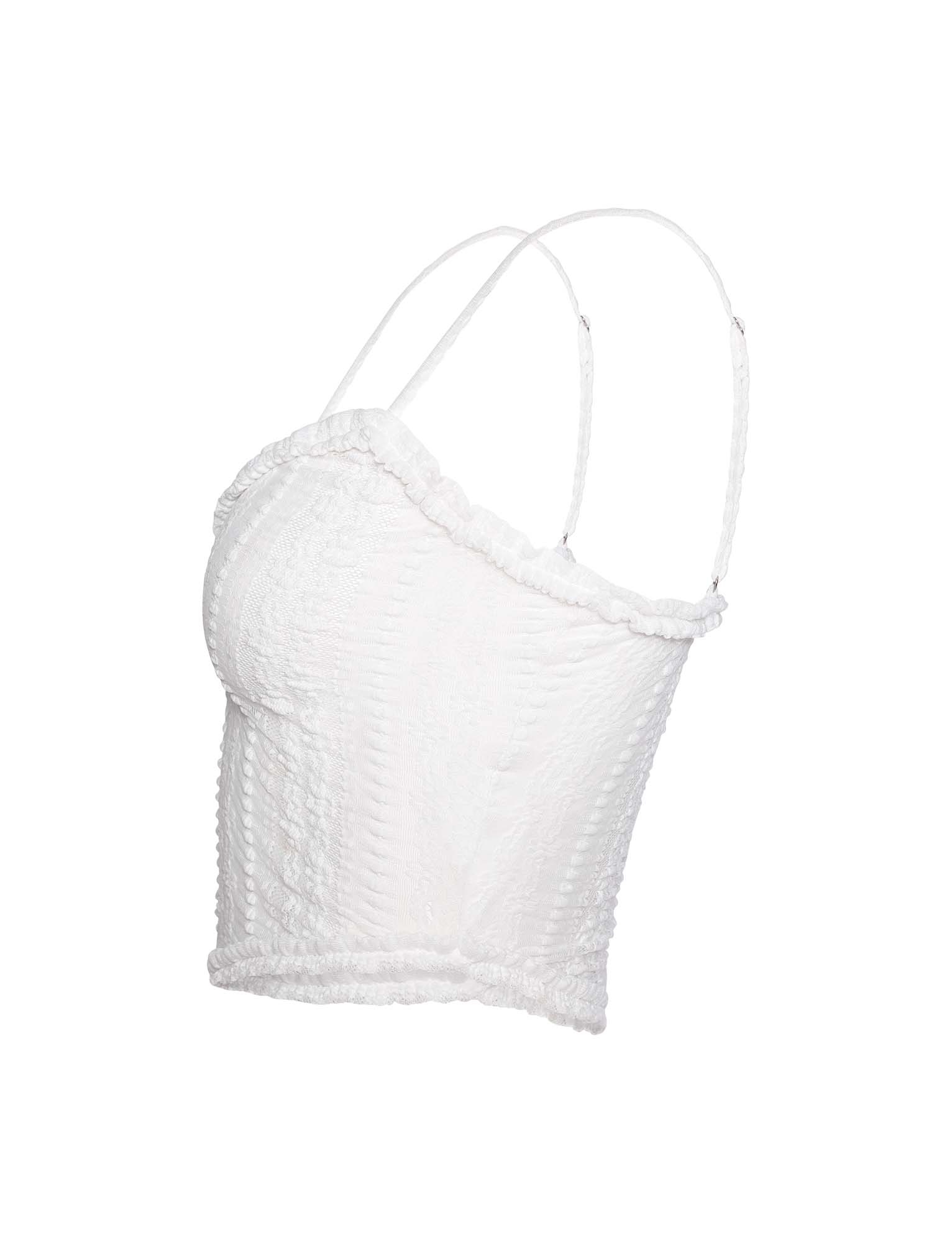 A side view of the SOPHA TWO PIECE TOP - WHITE by TIGERMIST reveals a textured, sleeveless crop top with thin spaghetti straps, featuring slight ruffle detailing along the neckline and hem.