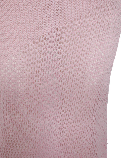 Close-up of the MACAULEY SKIRT in Baby Pink by TIGERMIST. The light pink knit fabric boasts an airy, see-through texture, highlighting the intricate pattern of holes created by its knitting technique. The background is partially visible through the fabric's open weave.
