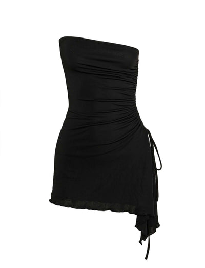 The XENIA MINI DRESS - BLACK from TIGERMIST is a strapless black mini dress with a bodycon silhouette, side ruching, and an asymmetrical hemline.