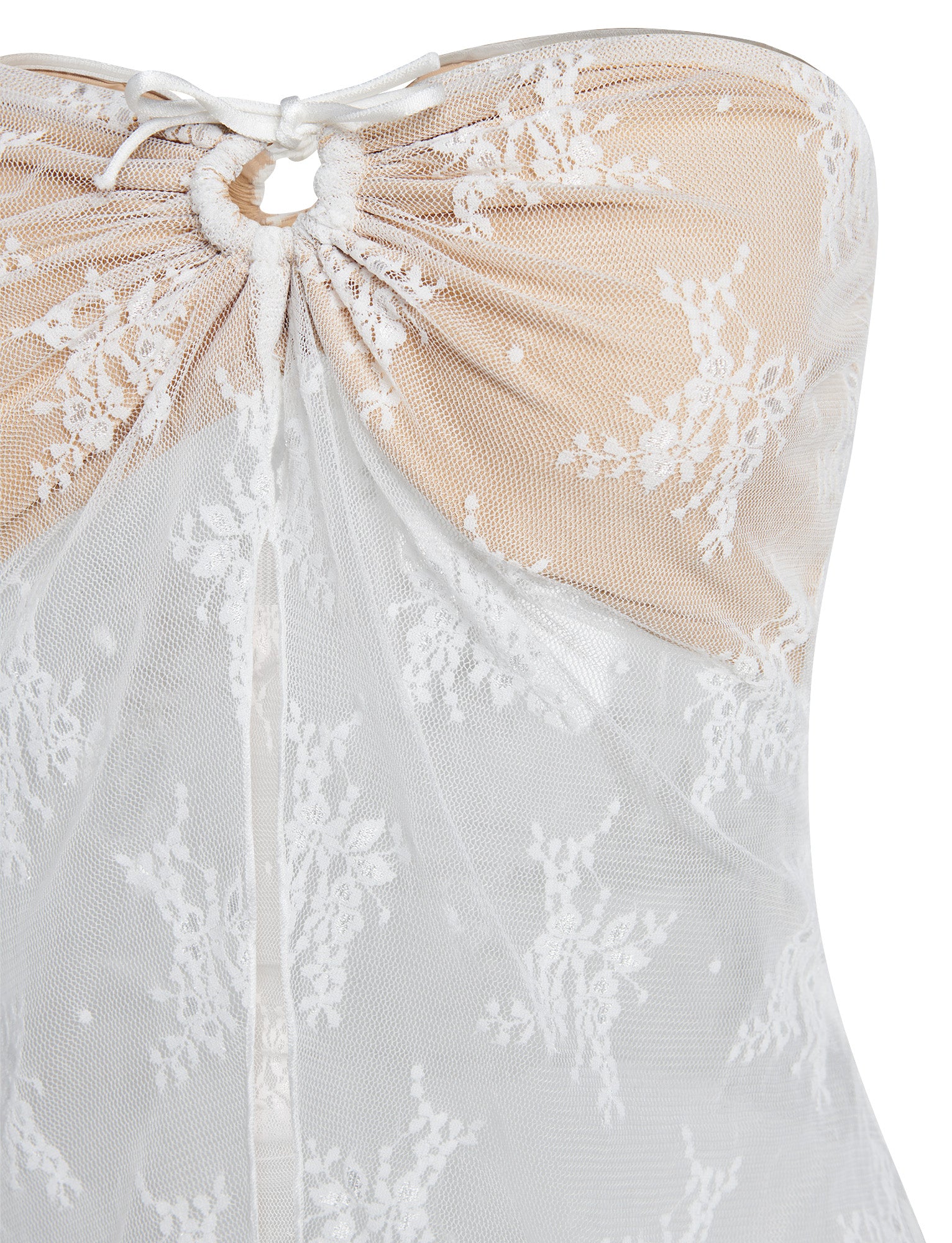 Close-up of the KAROLINA TOP - WHITE from TIGERMIST, showcasing intricate floral lace patterns. This strapless white top features a sweetheart neckline with a gathered bust and is accented by a small bow at the center. Sheer lace overlays nude fabric, creating a delicate and elegant appearance.