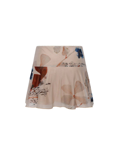 The skirt by TIGERMIST, named the FEYRA SKIRT - NEUTRAL : PAISLEY : BY POPPY BUTTERFLY, is an above-the-knee design with a floral pattern featuring large blue and brown flowers. It boasts a flowy, lightweight construction and is made from semi-sheer fabric with a subtle sheen. The floral print also includes faint cursive text integrated seamlessly into the design.