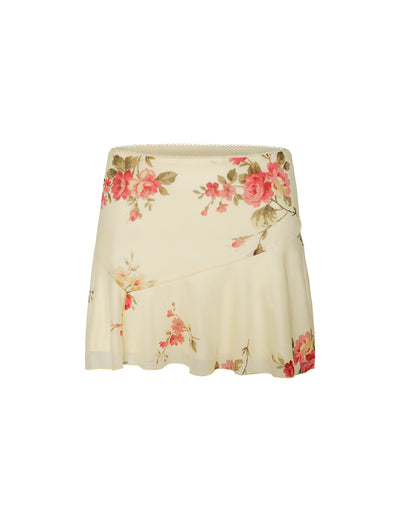 The FEYRA SKIRT by TIGERMIST in yellow with a pop floral macro pattern features pink and red roses scattered throughout, accompanied by an asymmetric hem and ruffled detail on one side.