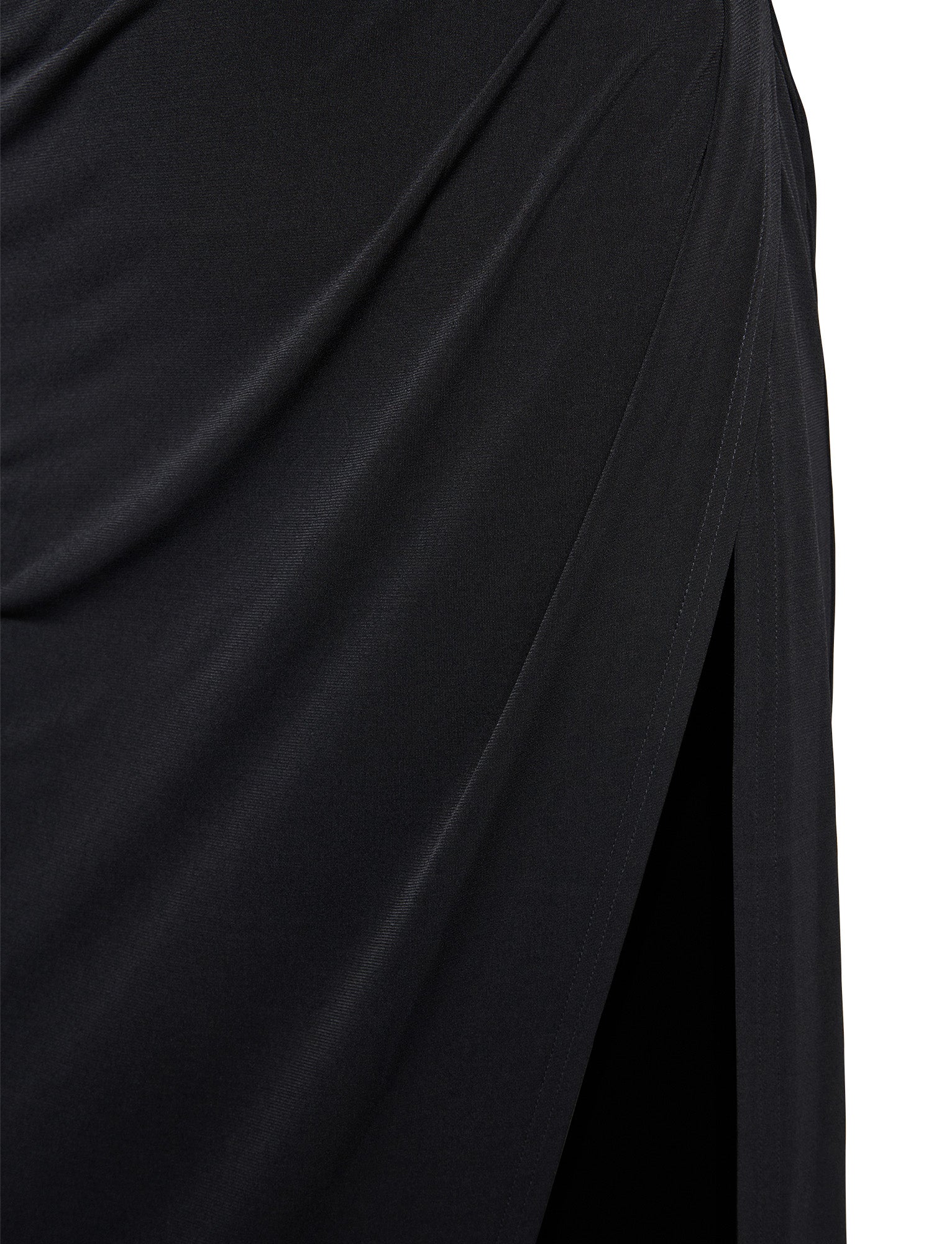 Close-up of black fabric draped in soft folds, showcasing the elegance and flowing appearance of the JOSLIN MAXI DRESS - BLACK from TIGERMIST. The material has a smooth texture, and the draping forms a slight diagonal pattern that embodies Tiger Mist's stylish designs. The image highlights the dress’s graceful and fluid quality.