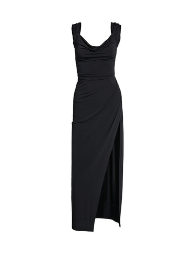 The JOSLIN MAXI DRESS by TIGERMIST is a black sleeveless evening gown featuring a draped neckline and ruched detailing on the sides. This sophisticated dress showcases a fitted silhouette with an asymmetrical hemline, creating a high slit on one side. The soft, flowing fabric makes it the perfect choice for an elegant night out.