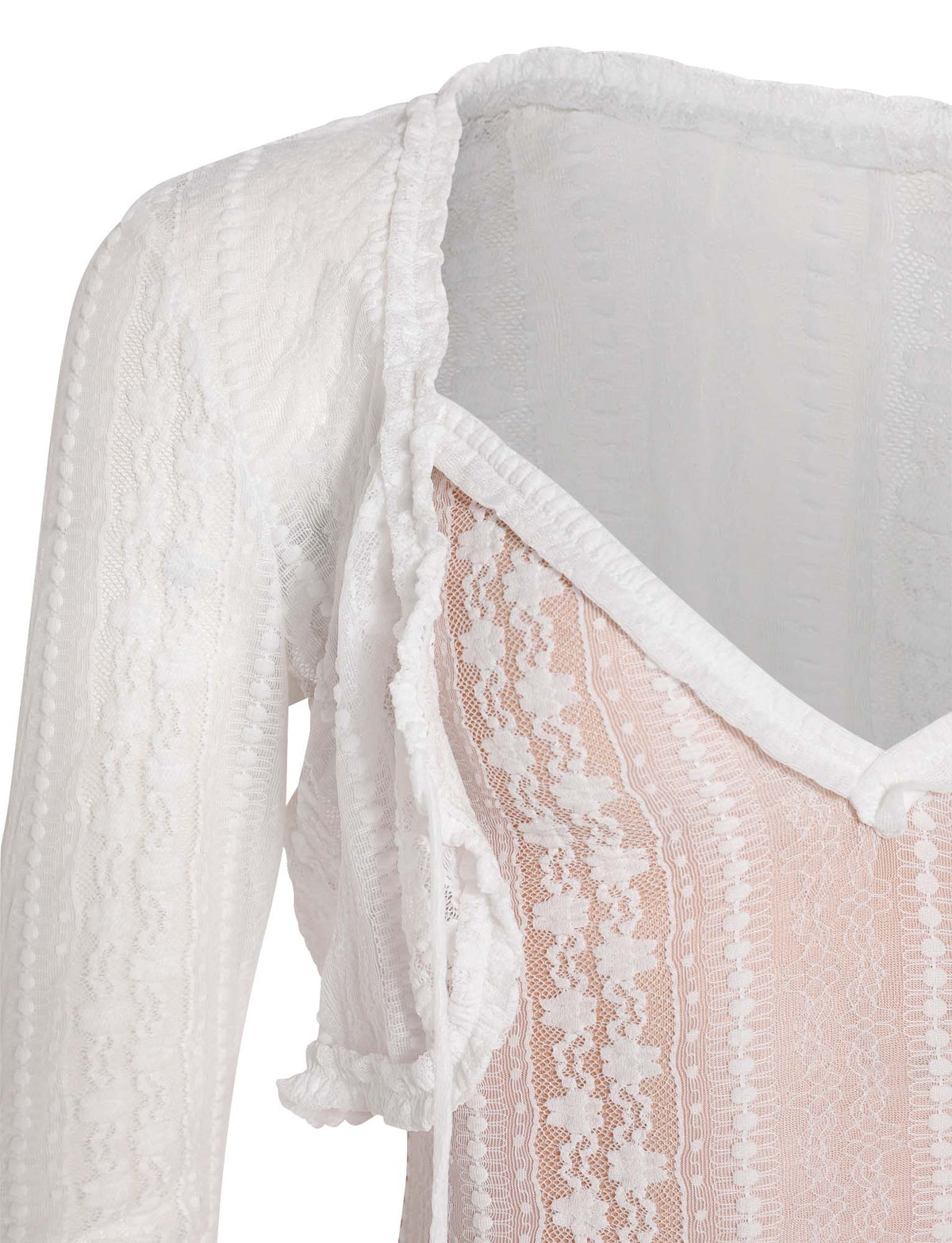 A close-up of the SOPHA TWO PIECE DRESS - WHITE from TIGERMIST showcases its exquisite lace detailing. The white lace, with an intricate pattern, overlays a nude-colored underlayer. Sheer long sleeves and a v-neckline enhance the elegance of the dress, while the edge of the neckline is adorned with a delicate ruffled trim.